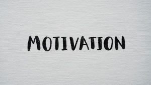 Inspirational word 'Motivation' in black on a white textured canvas background.